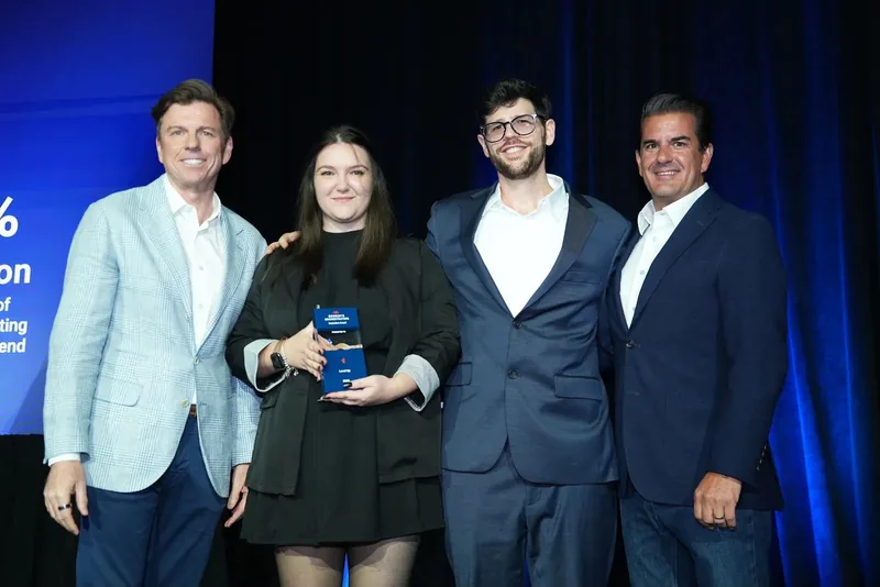 Lorena Lovric on stage holding the Genesys Orchestrators Innovation Award, with three colleagues